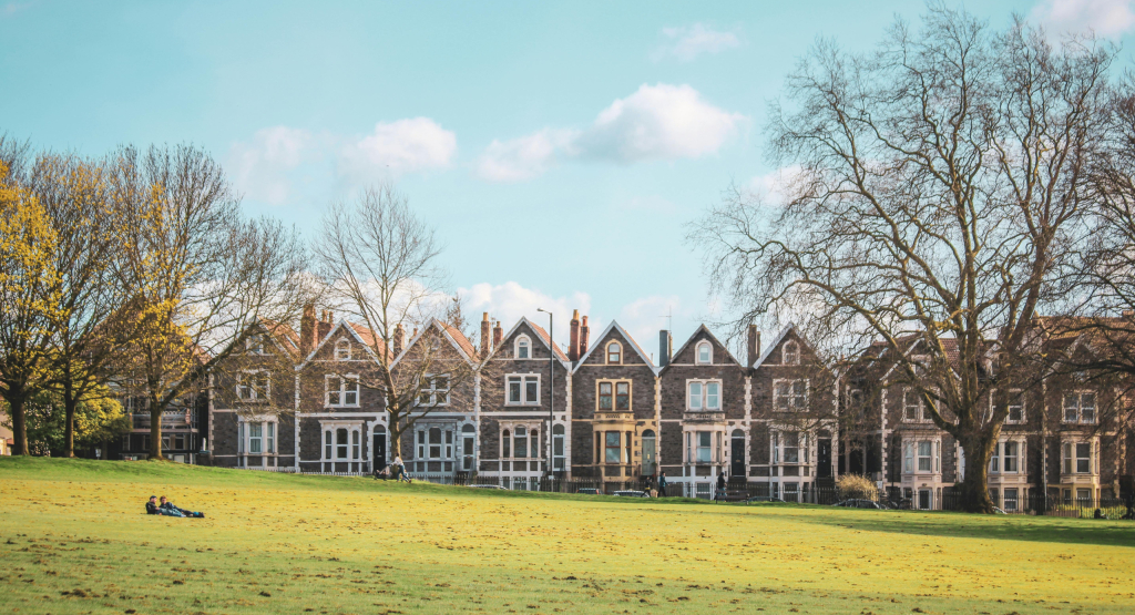 Bristol terraced housing by a park with two people realxing on the grass